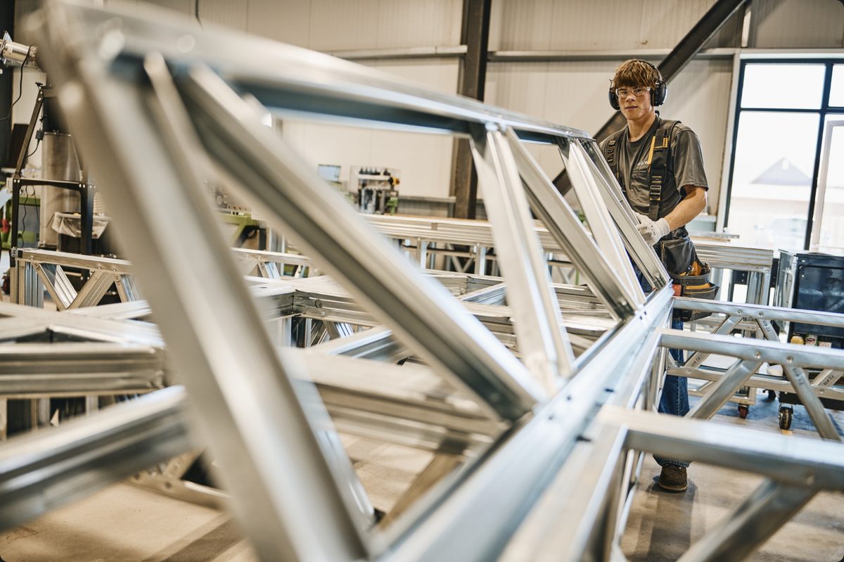 A HOWMZ fabricator assembling a steel wall frame in the factory
