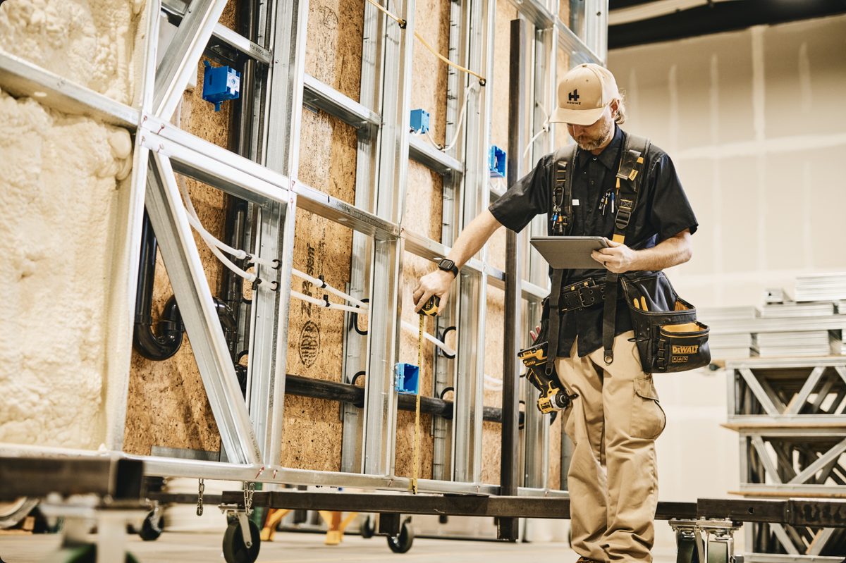 A HOWMZ wall panel on the factory line being checked against the build instructions